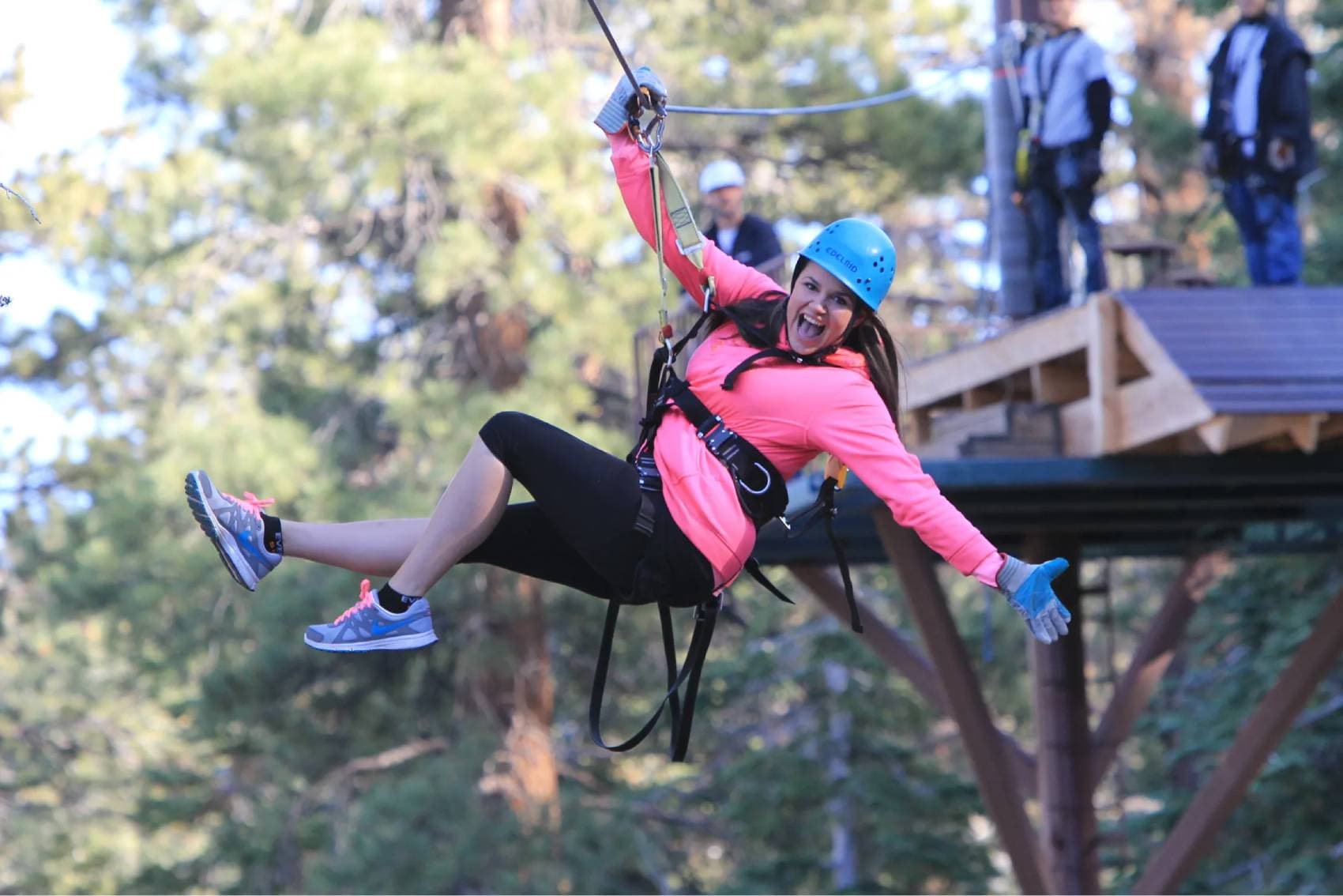 A rider launching off the platform onto a zipline, mid-cheer