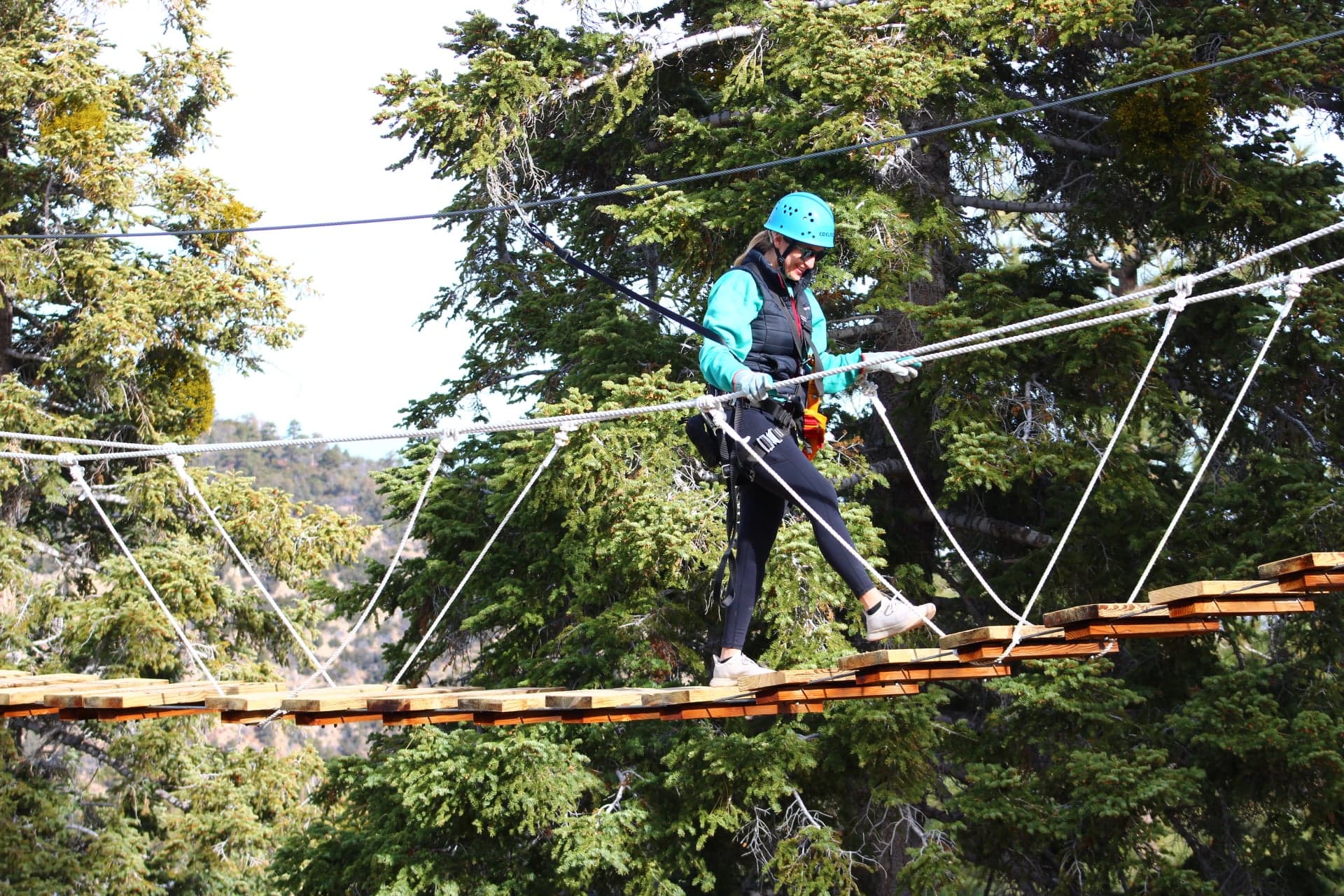 Crossing the suspension bridge between zipline platforms in the treetops