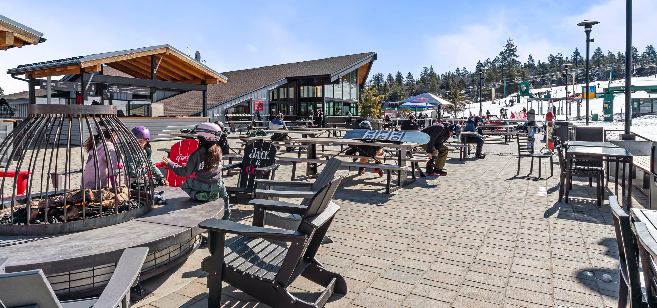 The Bear Mountain base lodge and sun deck, fire pit and chairlift beyond