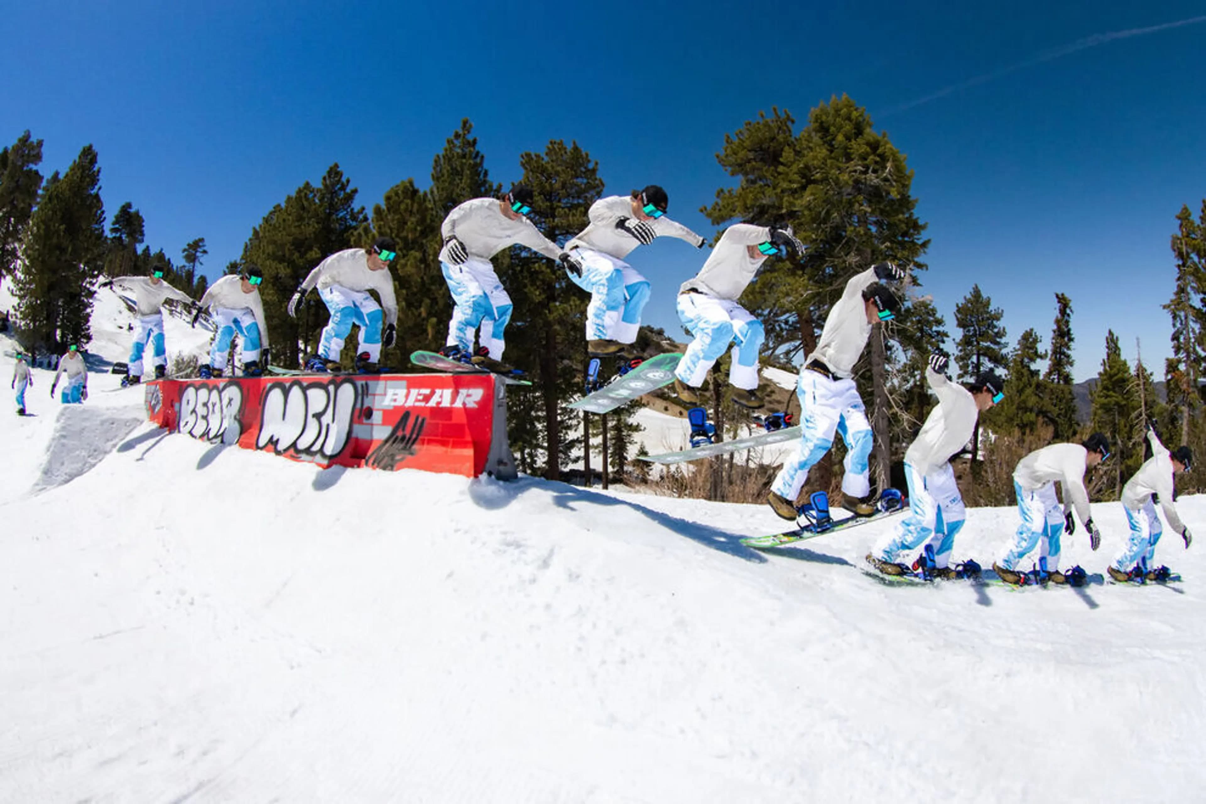 A snowboarder sliding a Bear-branded park rail, captured as a multi-exposure sequence