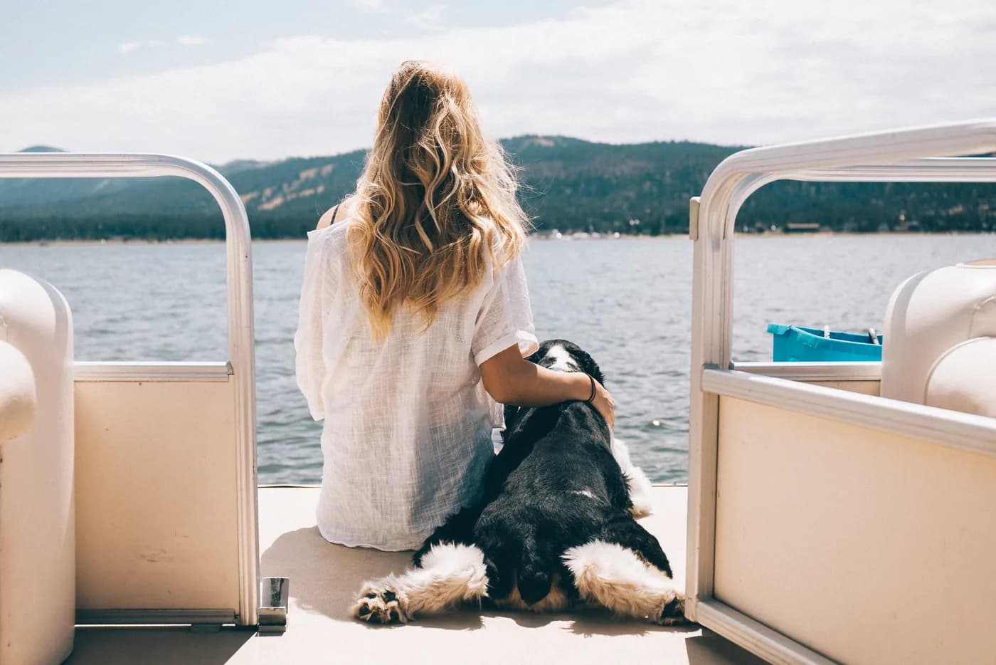 A pontoon boat out on Big Bear Lake with a dog settled on the deck