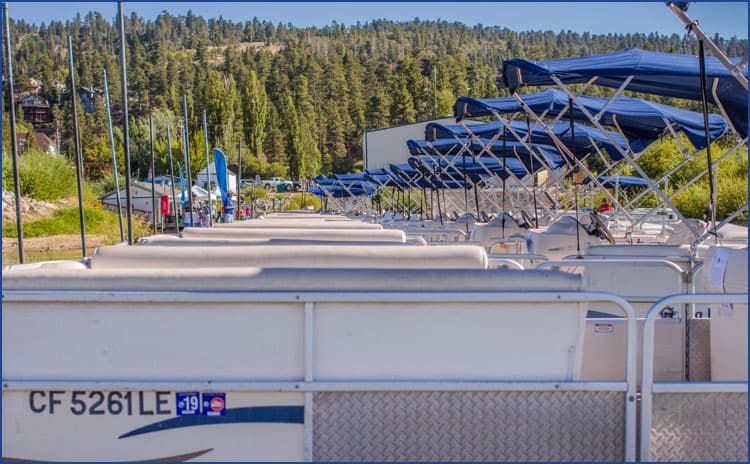 A row of Big Bear Marina pontoon boats lined up at the dock