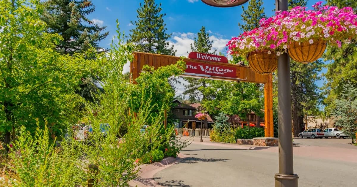 The 'Welcome to The Village' arch sign in Big Bear Lake on a summer day
