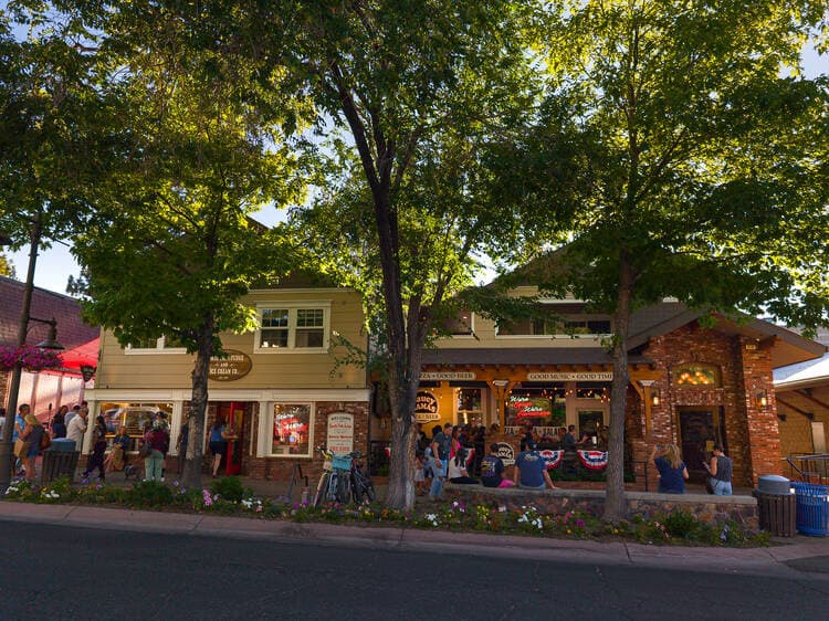 Shops and a restaurant patio along Pine Knot Avenue in The Village
