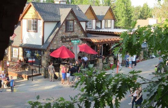 Outdoor dining under red umbrellas in The Village