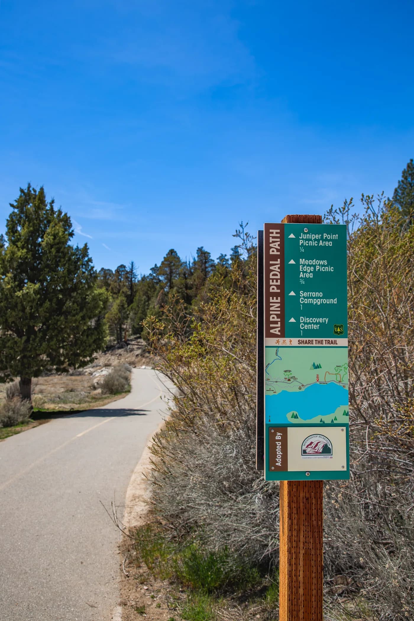 The Alpine Pedal Path trailhead sign where the paved path sets off along the north shore